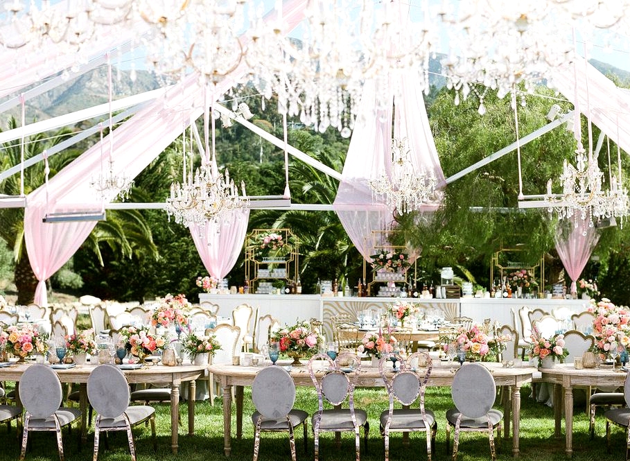 outdoor wedding with long table under a clear tent with pops of pink, coral and blue