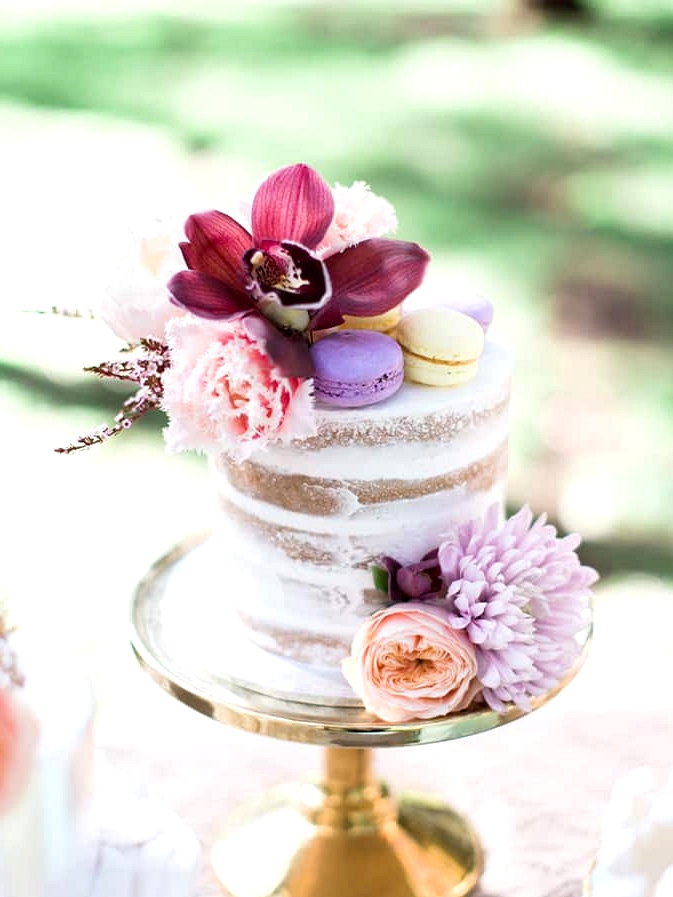 Naked wedding cake with macarons and pastel flowers