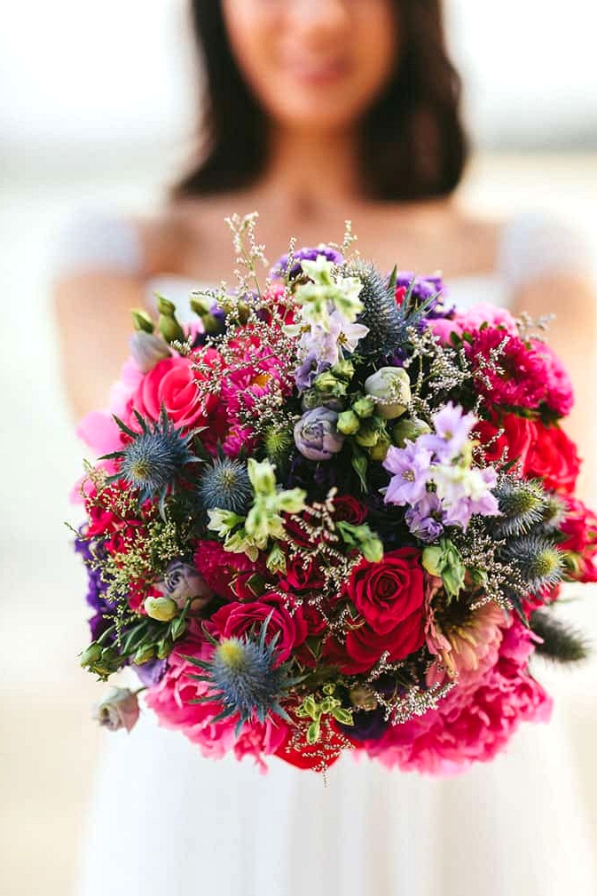 Bright and modern wedding bouquet with pink roses and blue thistle