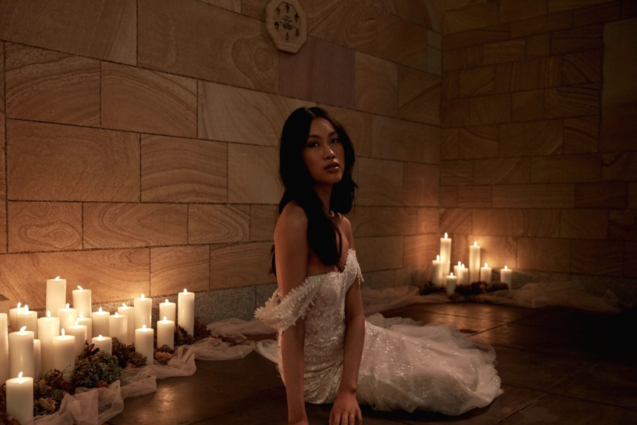 Sarai Dress model lying on church floor candles lighting veil