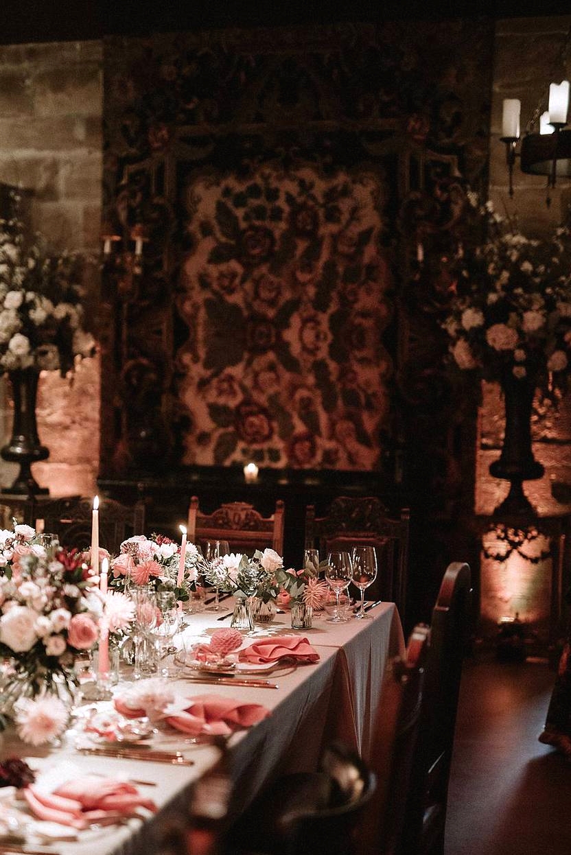 table setting with pink and red flowers and napkins at scottish castle wedding