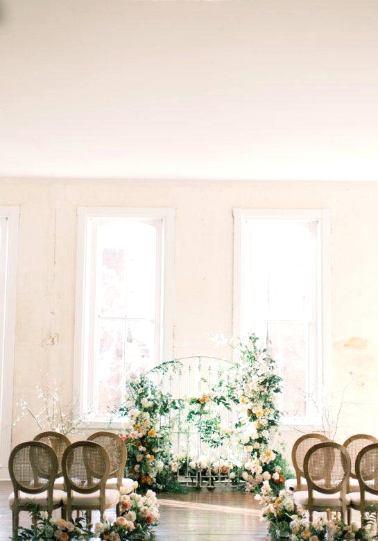 floral iron gate wedding backdrop with cane back dining chairs