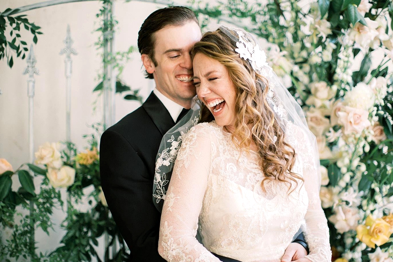 vintage inspired wedding dress with embroidered lace and pearl embellishments with a vintage lace bridal veil and a black groom tux