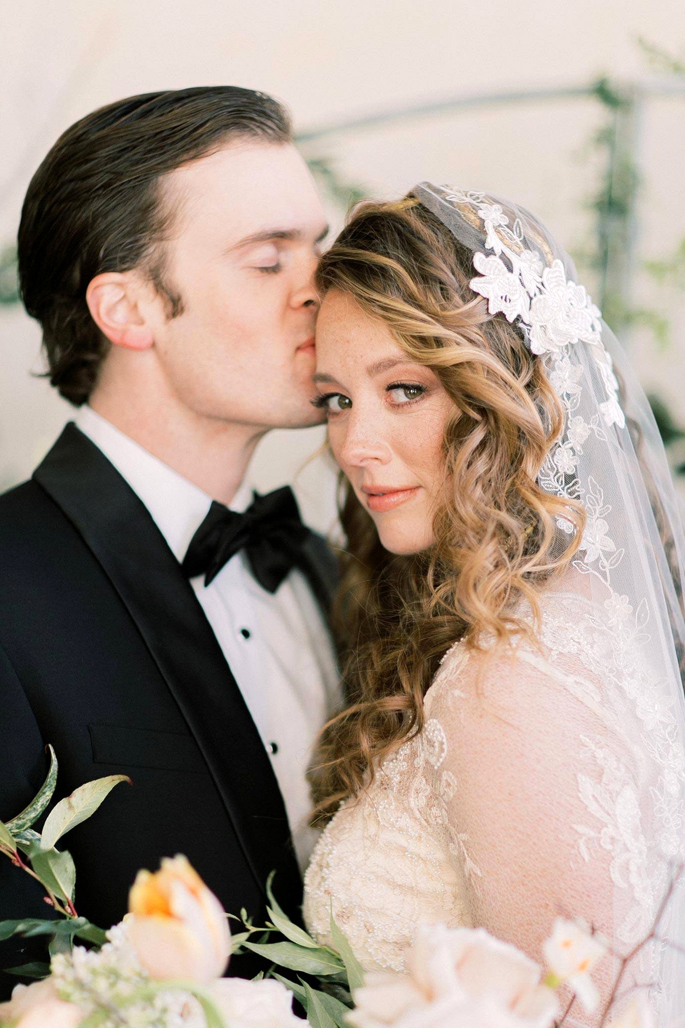 vintage inspired wedding dress with embroidered lace and pearl embellishments with a vintage lace bridal veil and a black groom tux