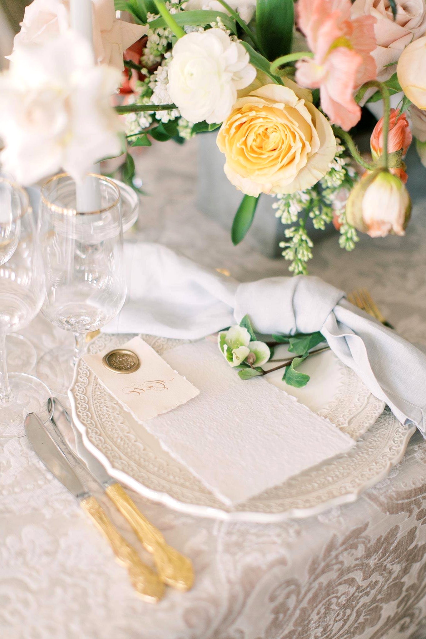 white letterpress menu with a calligraphed place card with a gold wax seal