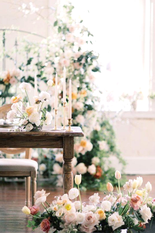 sweetheart table with box flower floor arrangements and a floralized gate backdrop