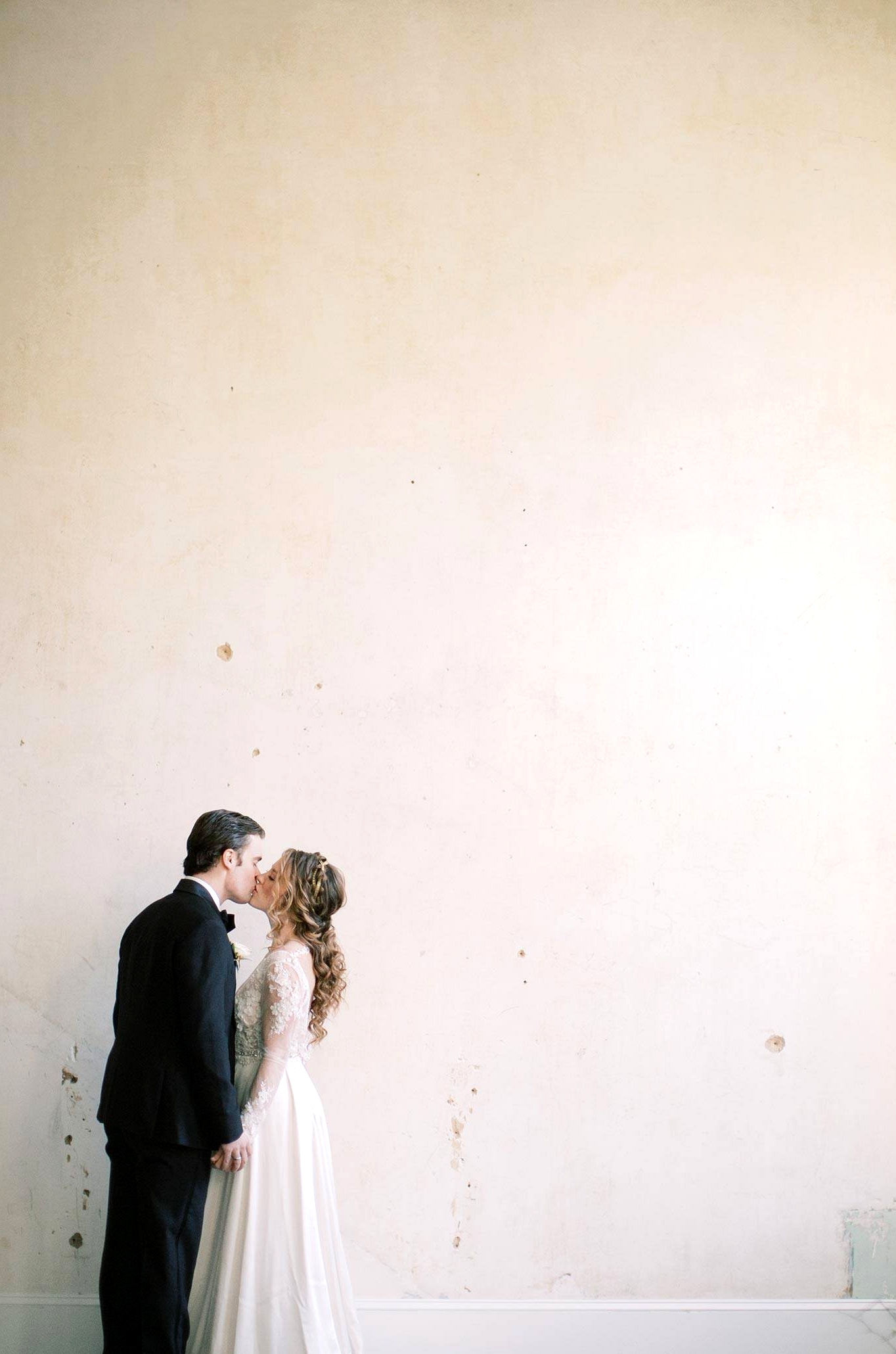 vintage inspired wedding dress with embroidered lace and pearl embellishments and a black groom tux