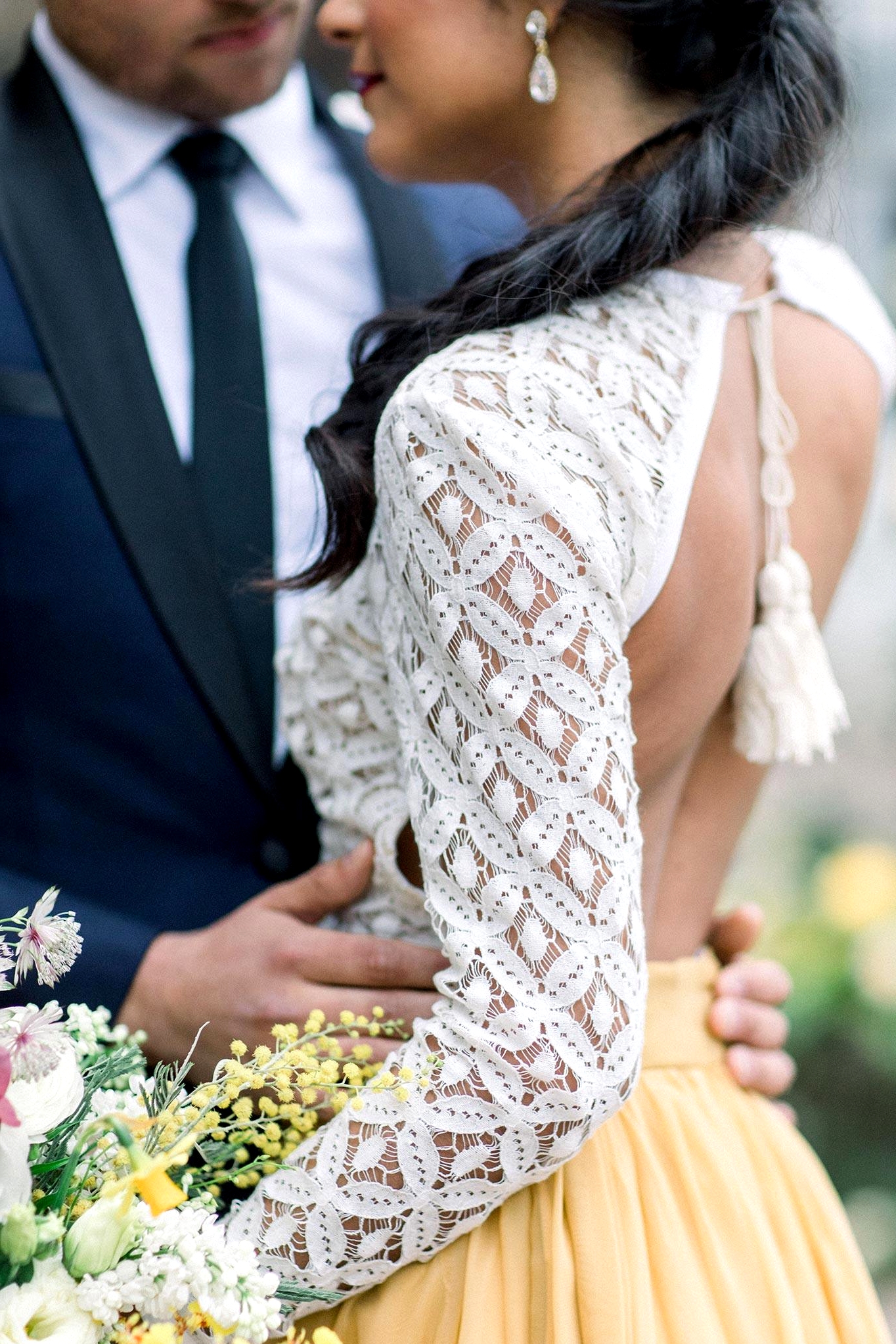 crochet lace top and mustard bridal skirt in this two piece wedding dress look with a colorful spring garden bouquet