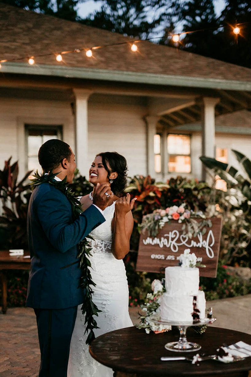 Maui wedding reception with a buttercream cake and hand calligraphed wedding signage on a wooden canvas