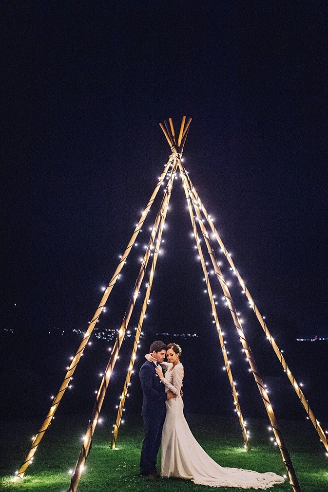 After dark wedding portraits beneath a naked tipi wrapped in fairy lights | Sophie Baker Photography