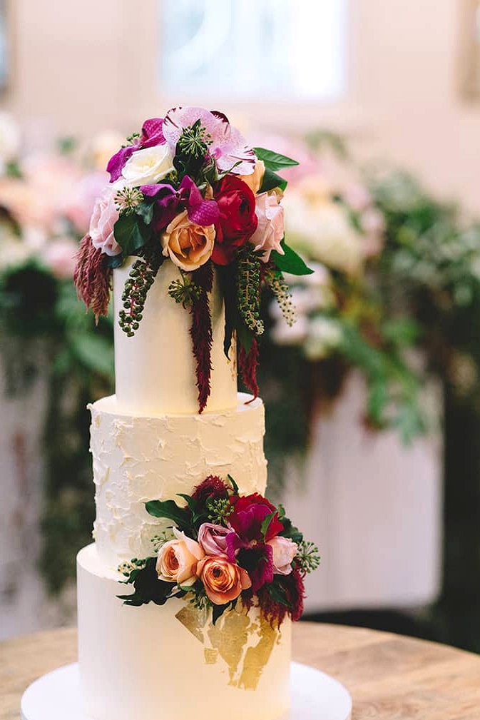 Romantic buttercream wedding cake topped with gold foil, pink roses and orchids | Vanessa Norris Photography
