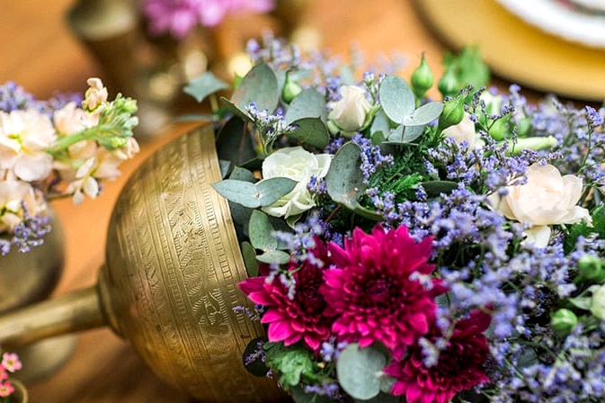 Brass cup spilling flowers