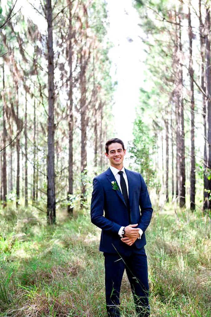 Groom wearing navy suit and dark blue tie