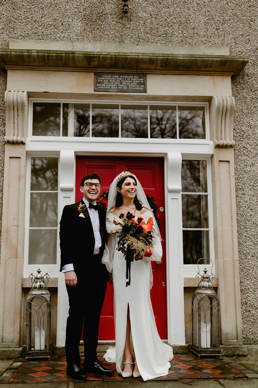 Bride and groom couple outside The Old Rectory Killyman with red door behind them