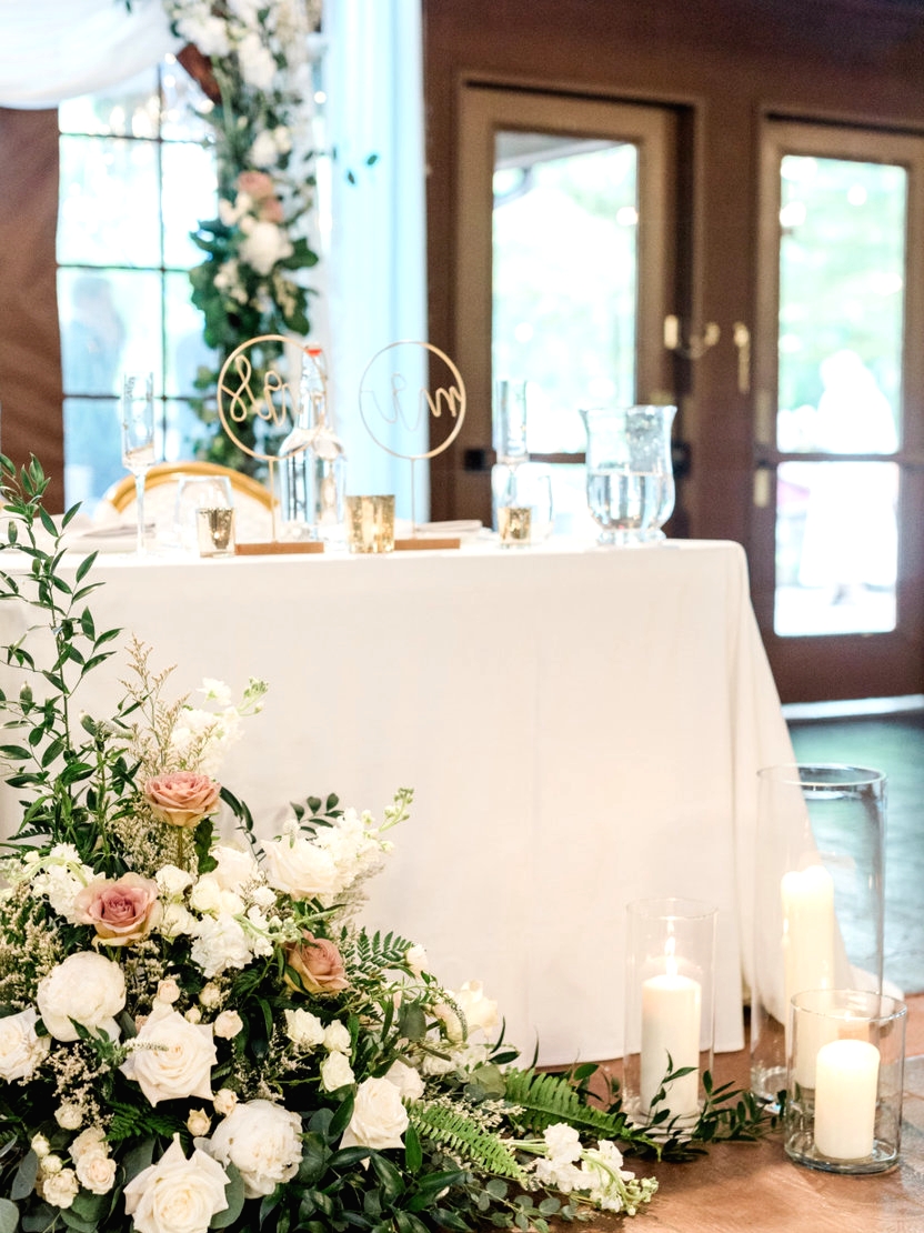 sweetheart top table with floral wooden arch in the background